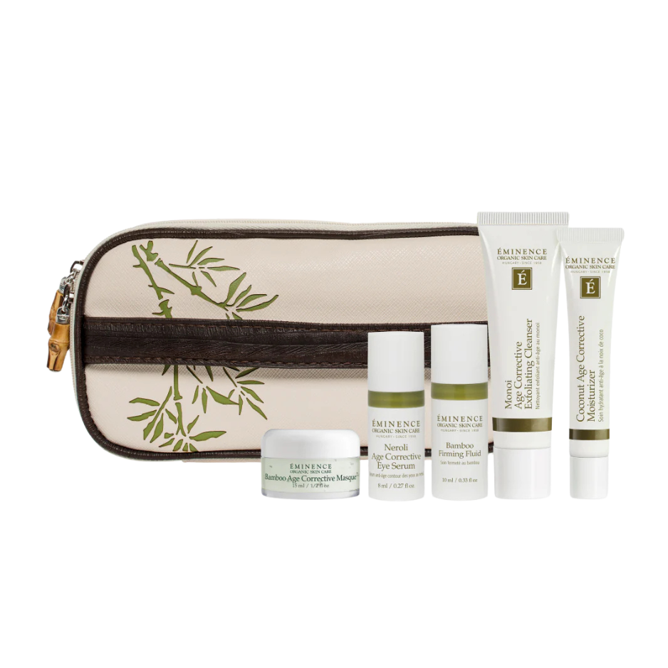 A collection of skin care products including cleanser, treatments, and moisturizers with a bamboo-themed travel bag.