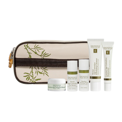 A collection of skin care products including cleanser, treatments, and moisturizers with a bamboo-themed travel bag.