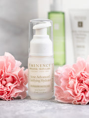 Eminence skincare bottle with pink flowers on a light background