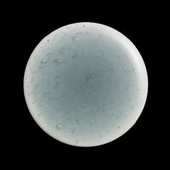 Round cleanser swatch with a speckled design on a white background