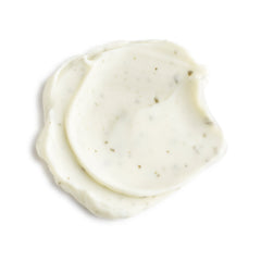 Two swatches of white cream on a light beige background