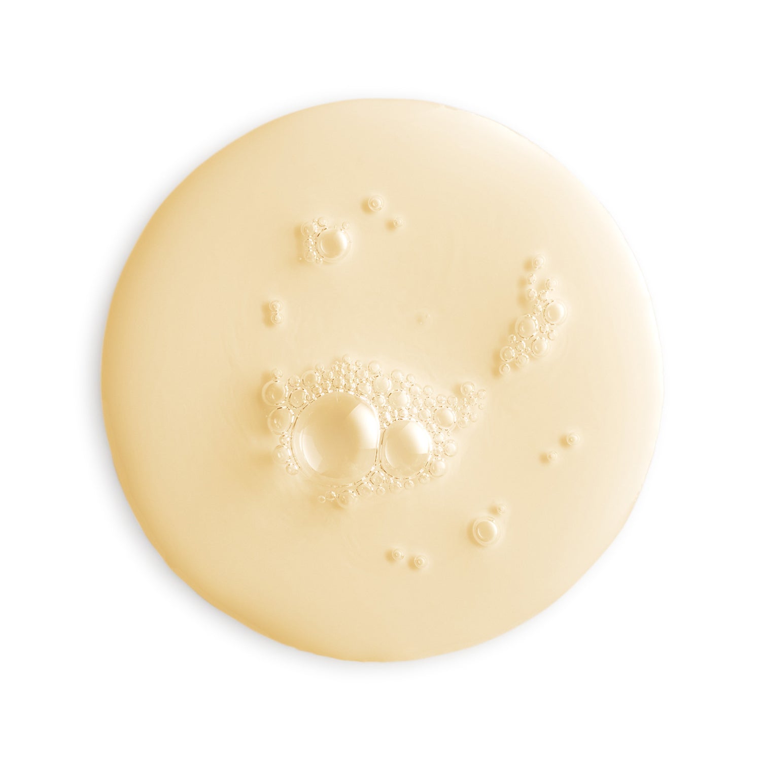 Close-up of a beige cream or lotion with bubbles on a white background