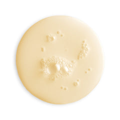 Close-up of a beige cream or lotion with bubbles on a white background