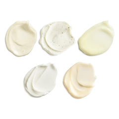 Six swatches of white cream on a light beige background