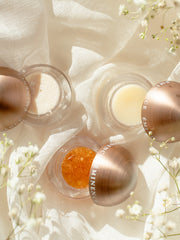 Cosmetic jars with gold lids on a soft fabric background