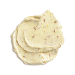 Close-up of a swirl of creamy white substance with specks on a white background