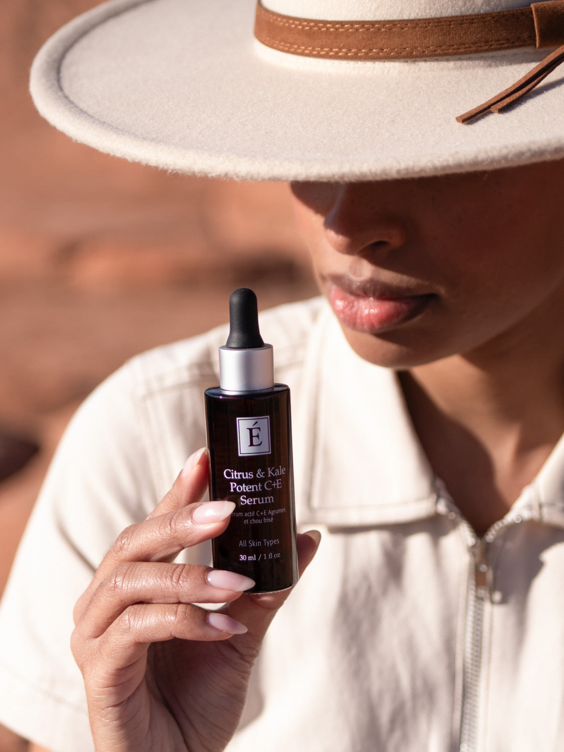 Person holding a skincare product bottle with a blurred background