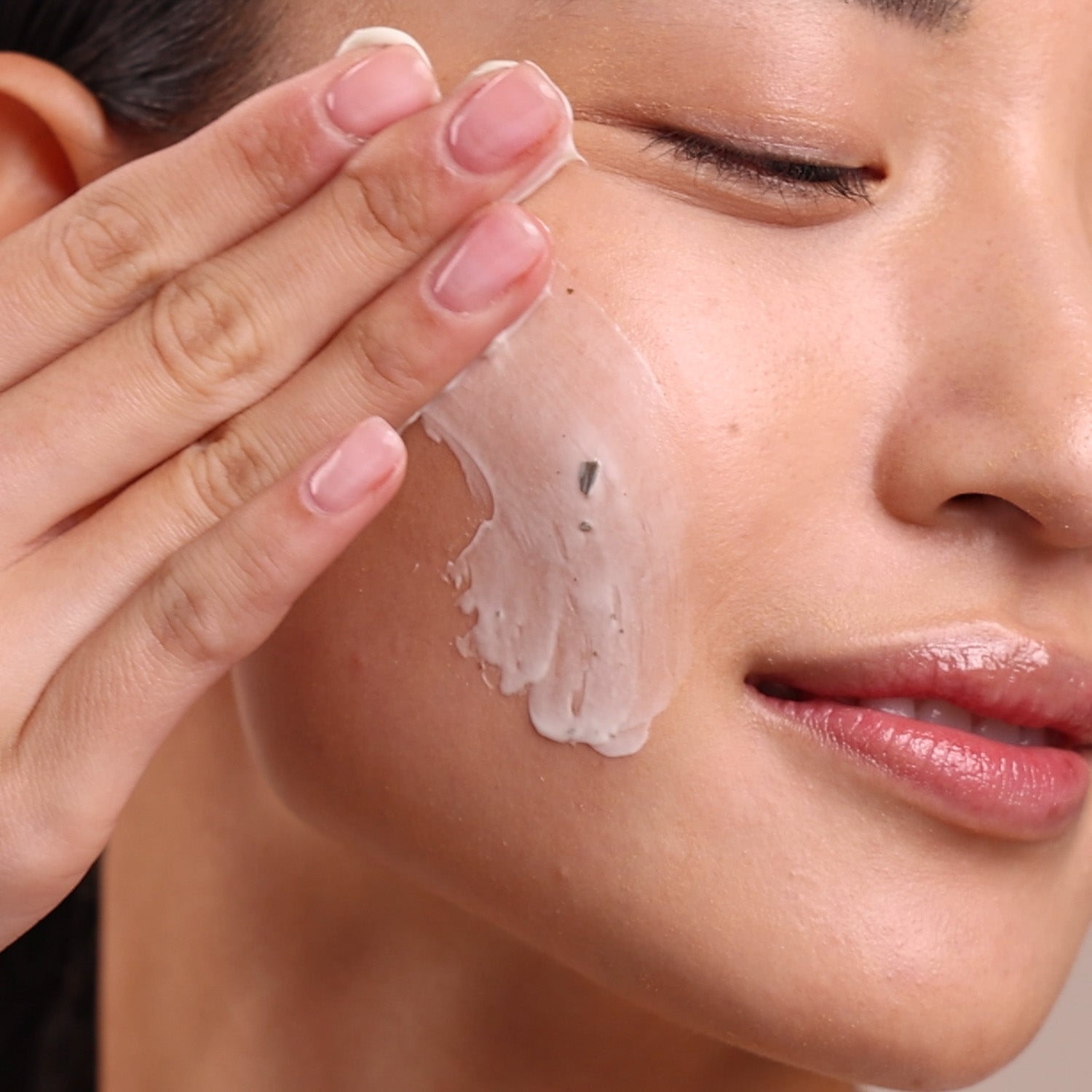 Close-up of a person applying cream to their face