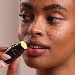 Person applying lipstick with a focus on the action
