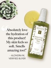 Green bottle of Eminence Stone Crop Hydrating Mist with a yellow oil blob and succulent plant on a white background.