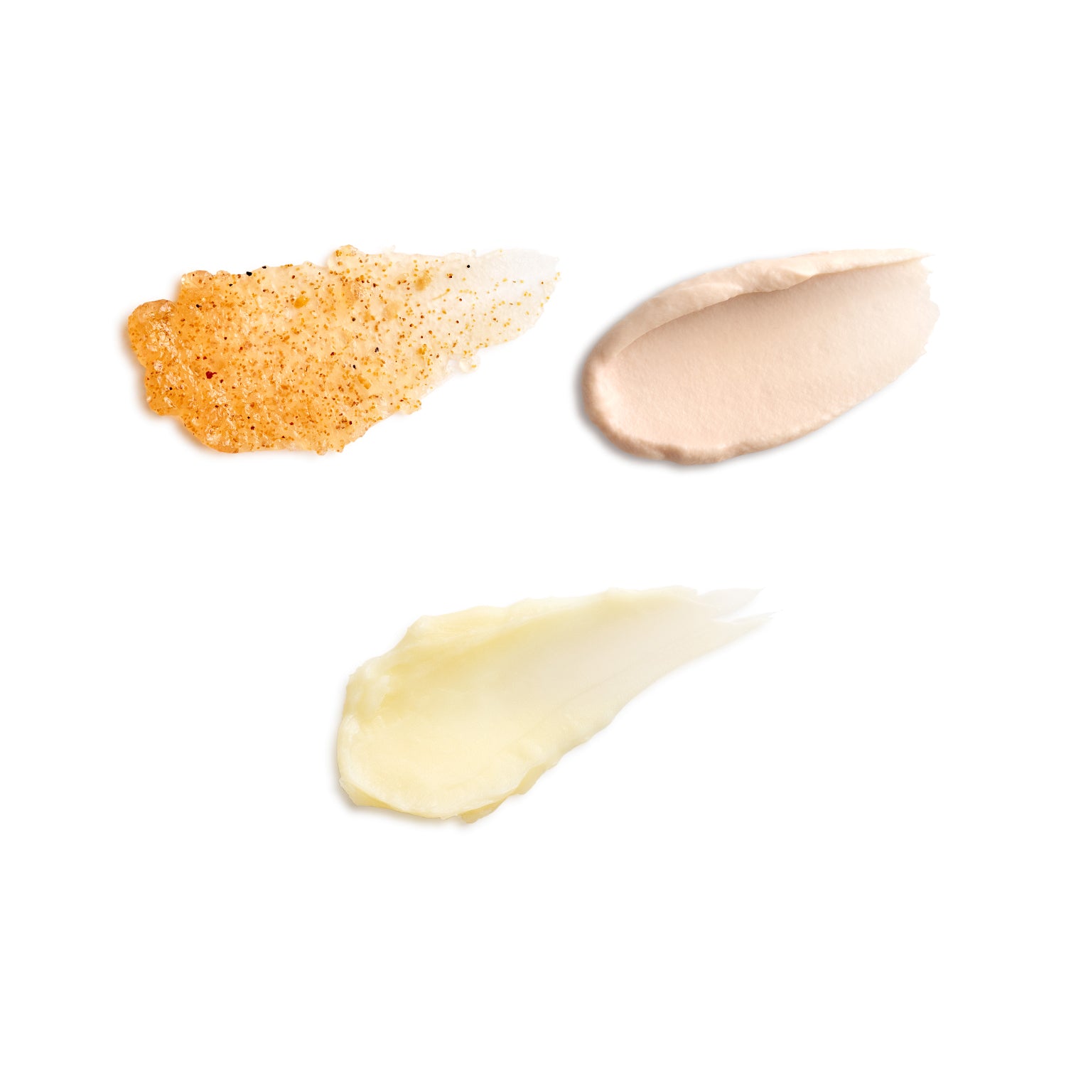 Three swatches of different colored creams on a white background